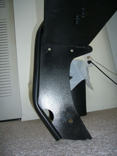2000 Ford Crown Victoria - A black metal component with a textured finish and curved edge is shown, likely a vehicle part.