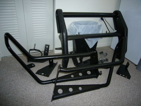 2000 Ford Crown Victoria - Aftermarket bull bar and its associated mounting hardware are displayed on a carpeted floor.