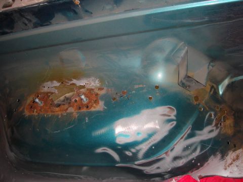 1996 Ford Bronco - The interior floor of a 1996 Ford Bronco shows significant rust damage and evidence of repair work.