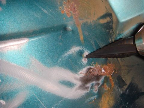 1996 Ford Bronco - Close-up of a teal car floor showing rust damage and repair work in progress.