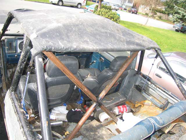 Interior of a modified off-road vehicle with roll cage and worn seats