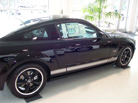 1996 Ford Bronco - A black Ford Mustang Shelby GT is shown from the side in a showroom.