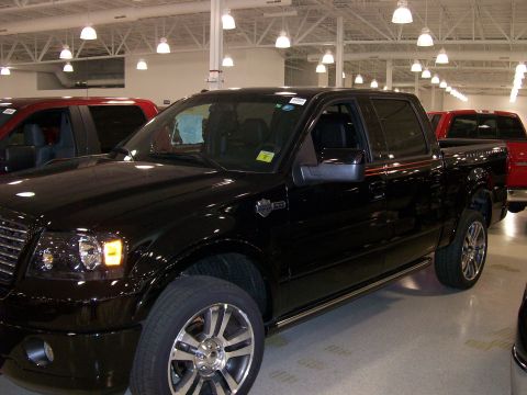 1996 Ford Bronco - A black Ford F-150 truck is parked indoors with other vehicles visible.