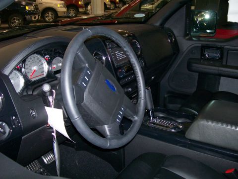 1996 Ford Bronco - The interior of a truck is shown, a steering wheel with a blue Ford emblem and a prominent Supermotors watermark at the bottom.
