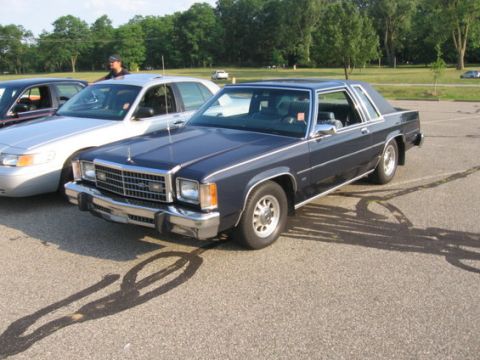 1988 Mercury Grand Marquis - A 1988 Mercury Grand Marquis coupe is parked in a lot next to a silver sedan.