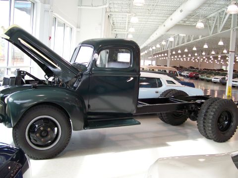 1996 Ford Bronco - A dark green truck chassis is viewed from the side with its hood open, revealing the engine bay.
