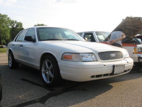 1988 Mercury Grand Marquis - A white sedan with its hood open is parked next to another vehicle.