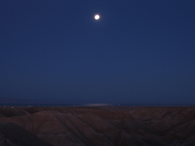 moon over desert hills at dusk
