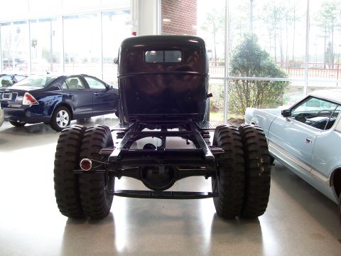 1996 Ford Bronco - The rear view of a truck chassis with large dual wheels is visible, with other vehicles in the background.