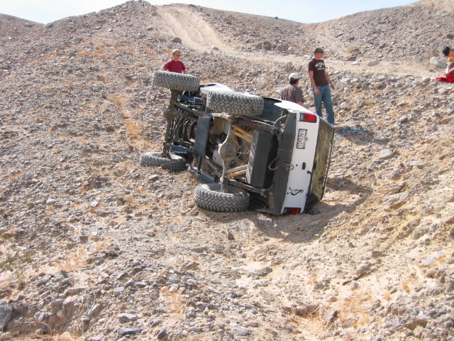 White 1997 Ford Ranger on its side on a rocky hill