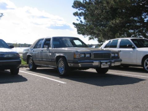 1988 Mercury Grand Marquis - A 1988 Mercury Grand Marquis is parked outdoors, with another vehicle to its right.