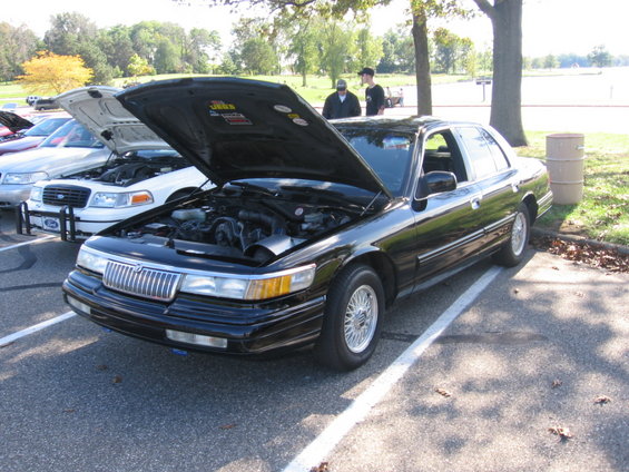 Black 1988 Mercury Grand Marquis with hood open, parked next to other cars