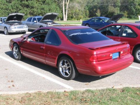 1988 Mercury Grand Marquis - Several cars are parked in a lot, with some of their hoods open, suggesting a car show or gathering.