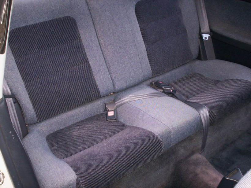 Gray cloth rear bench seat interior of a coupe