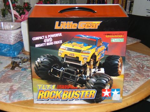 1988 Ford Bronco - The box for a Tamiya TLT-1 Rock Buster RC monster truck is displayed on a table.