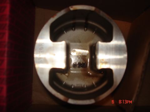 1994 Ford Probe - A single engine piston is shown, with some visible markings and oil residue.