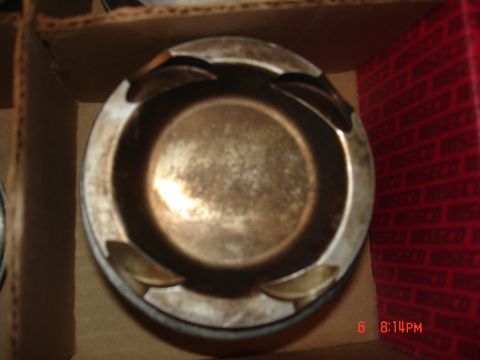 1994 Ford Probe - A single piston is shown in a cardboard box, with a red box with a brick pattern visible on the right side.