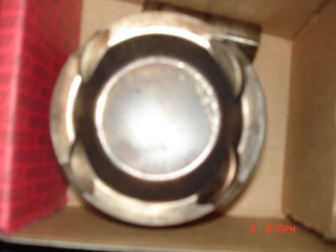 1994 Ford Probe - Close-up of an engine piston, likely new or rebuilt, in packaging.