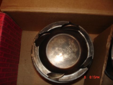1994 Ford Probe - A close-up view of an engine piston, likely a replacement part, is shown inside a cardboard box.
