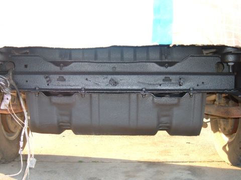 1978 Ford Bronco - The rear section of a vehicle's undercarriage, a newly painted fuel tank and frame components.