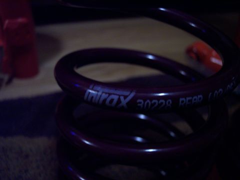 2003 Ford Focus - Close-up of a purple coil spring, possibly for a vehicle, with "mirax 30228 REAR" printed on it.
