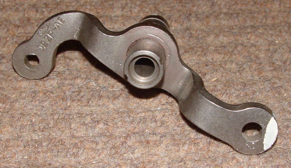 Bare Ford-stamped steel transmission shift lever with splined bore on carpet