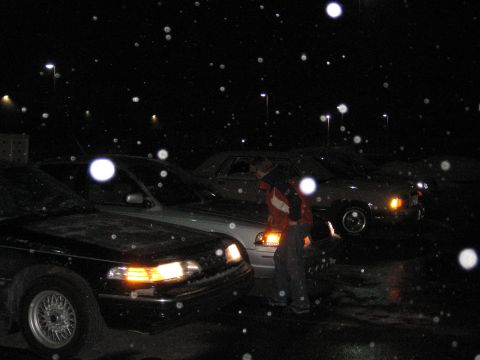 1995 Ford Thunderbird - Three cars are parked outside at night while snow falls.