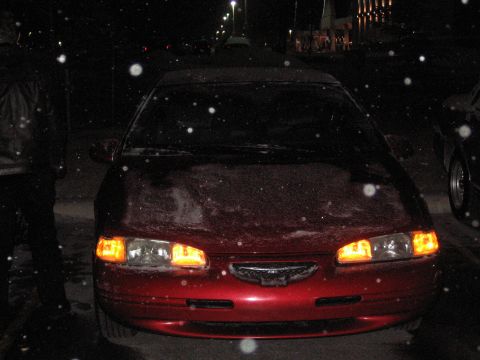 1995 Ford Thunderbird - Front view of a red car at night with snow falling.