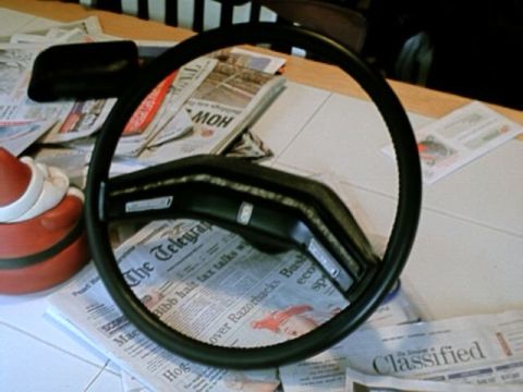 1976 Ford Ranchero - A steering wheel is placed on a table covered with newspapers.