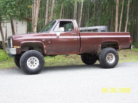 1982 Chevrolet C/K Pickup - This lifted pickup truck, believed to be a 1982 Chevrolet C/K, is shown from the side.