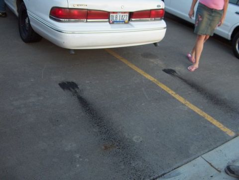 1988 Mercury Grand Marquis - Tire marks on pavement behind a white 1988 Mercury Grand Marquis.