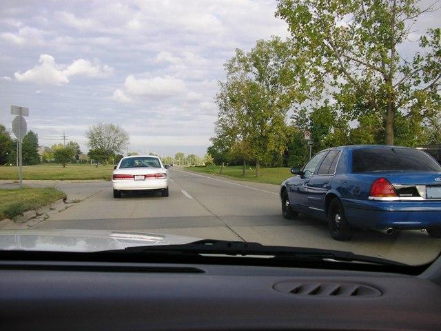 Blue police car from rear, white car ahead