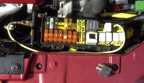 1997 Ford Taurus - Close-up view of a vehicle's electrical fuse box and relays, showing various components.