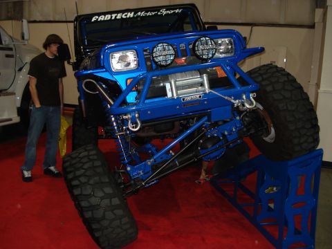 1994 Ford Bronco - A heavily modified off-road vehicle is displayed with its front end elevated.