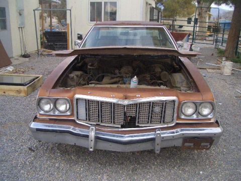 1974 Ford Ranchero - The front of a brown 1974 Ford Ranchero is shown with its hood open, revealing the engine compartment.