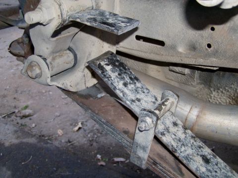 1967 Ford Bronco - Close-up view of a vehicle's rear suspension leaf spring and exhaust pipe.