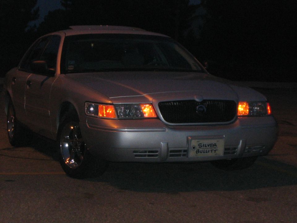 Silver Mercury Grand Marquis sedan at night with custom plate