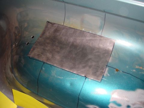 1996 Ford Bronco - A metal patch is prepared for installation on a teal vehicle's body, indicating repair work.