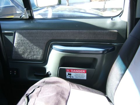 1991 Ford Bronco - A red danger sticker with a warning about slippery roads is affixed to the interior door panel of a vehicle.