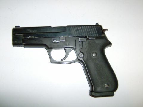 1982 Chevrolet C/K Pickup - A black semi-automatic pistol is shown against a white background.