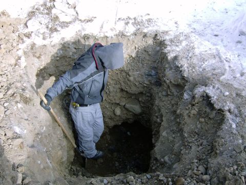 1982 Chevrolet C/K Pickup - A person digs a deep hole in the ground, with snow visible in the background.