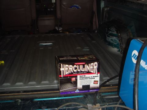 1996 Ford Bronco - A Herculiner bed liner kit is ready for application in the cargo area of a truck, alongside welding equipment.