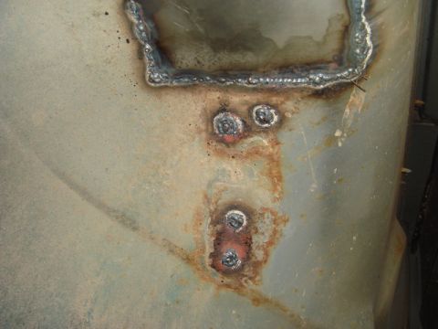 1996 Ford Bronco - Metal panel shows signs of rust and recent welding repairs.