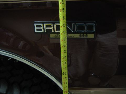 1996 Ford Bronco - Measuring tape against the side emblem of a 1996 Ford Bronco Eddie Bauer.