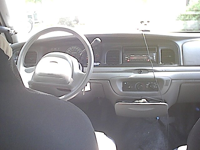 Interior of Crown Victoria showing steering wheel, dash and radio from passenger side