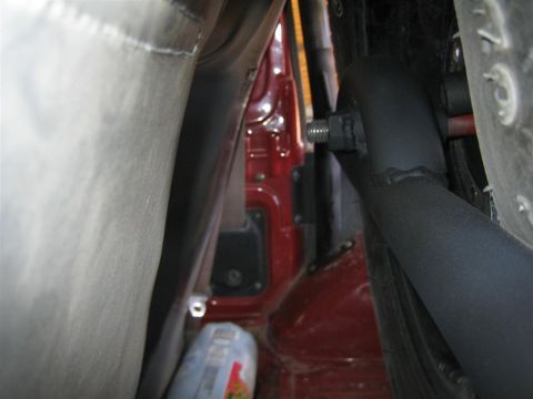 1987 Suzuki Samurai - A view into the interior of a vehicle, showing a black roll bar and red body paneling.