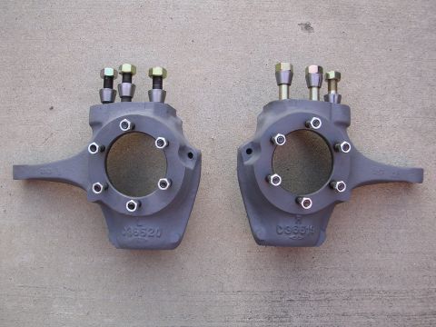 1999 Toyota Tacoma - A pair of steering knuckles, likely aftermarket parts, are shown against a concrete background.