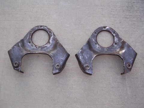 1999 Toyota Tacoma - Two metal suspension components are displayed on a concrete background, showing signs of wear and rust.