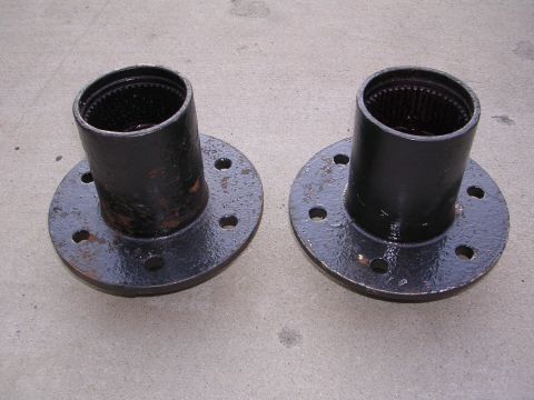 1999 Toyota Tacoma - Two black wheel hubs are shown, likely for a vehicle's front axle, with visible splines inside the cylindrical opening.