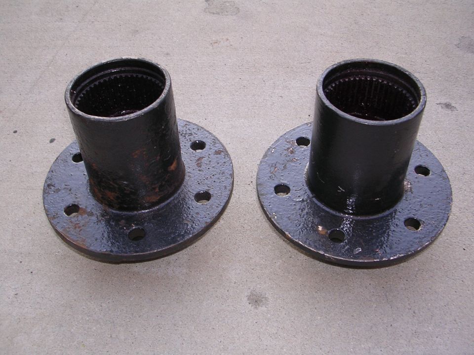 Pair of black wheel hubs with splined openings and bolt holes